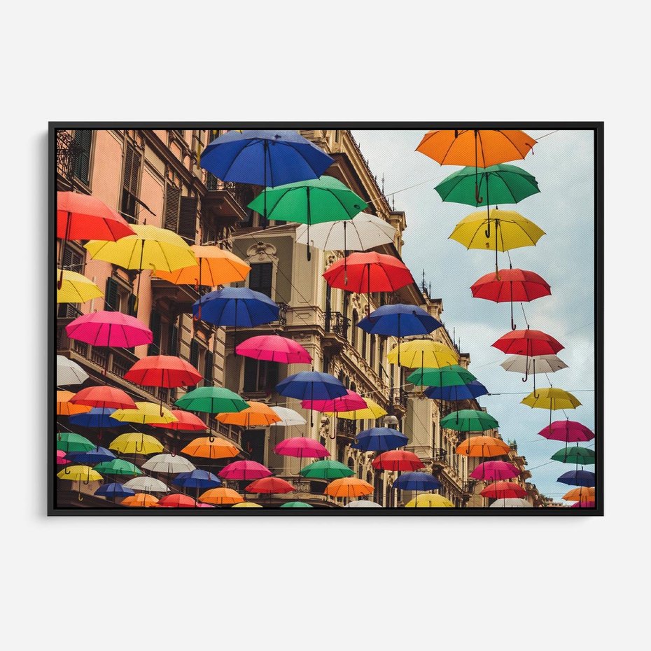 Obraz w ramie 70x50 - Barwna symfonia wyobraźni - fotografia, kolorowe parasolki podwieszone nad ulicą - rama czarna