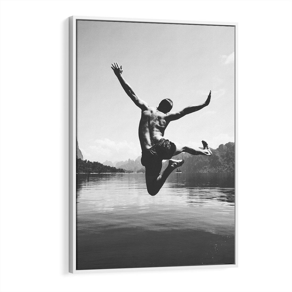 Obraz w ramie 70x100 - Beztroska Chwila - czarno biała fotografia, mężczyzna wesoło wskakuje do keziora w górach - rama biała