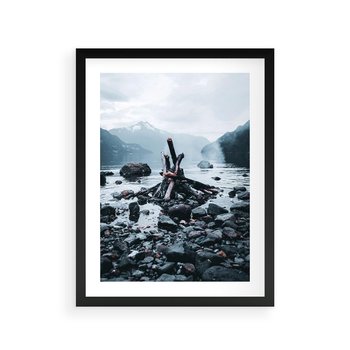 Plakat w ramie 40x50 - To ujęcie jeziora w górach z zgaszonym ogniskiem nad brzegiem, tworząc atmosferę spokoju i refleksji w otoczeniu przyrody. - jezioro w górach, zgaszone ognisko - rama czarna
