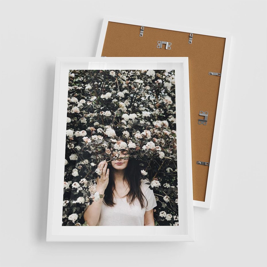 Plakat w ramie 50x70 - Kobieta w Krzewie Kwiatów - krzak z kwiatami, schowana za nim kobieta - rama biała
