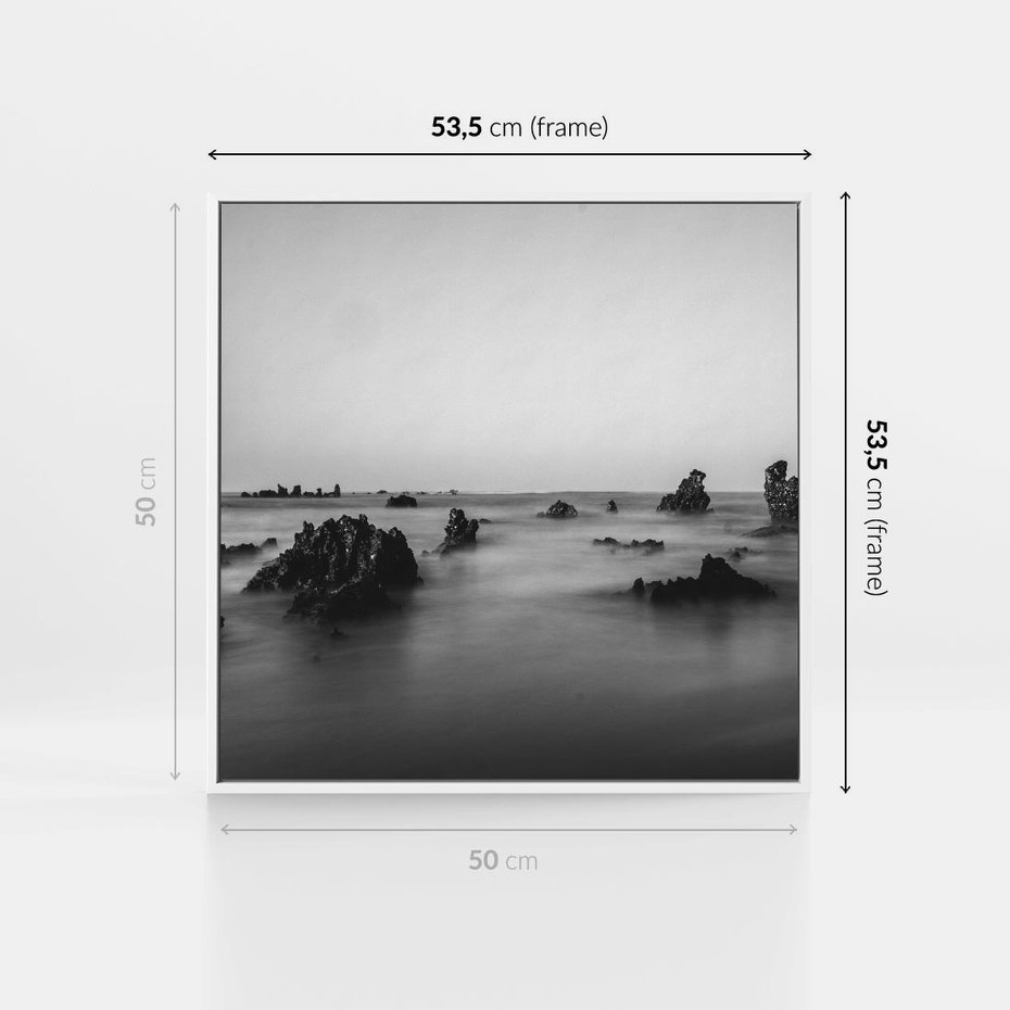 Obraz w ramie 50x50 - Harmonia świateł i cieni - zamglona dzika plaża, skały na plaży - rama biała