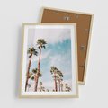 Plakat w ramie 50x70 - Tropikalna Sielskość: Palmy i Błękitne Niebo - palmy na tle błękitnego nieba - rama drewno