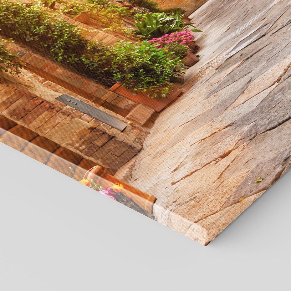 Obraz na płótnie 70x100 - Urok uliczki miejskiej z kwiatami - sklep, uliczka