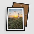 Plakat w ramie 50x70 - Magia latarni przy zachodzie - latarnia, zachód - rama czarna
