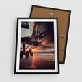Plakat w ramie 50x70 - Podróż ku Zachodzącemu Słońcu - samolot, scena na lotnisku - rama czarna