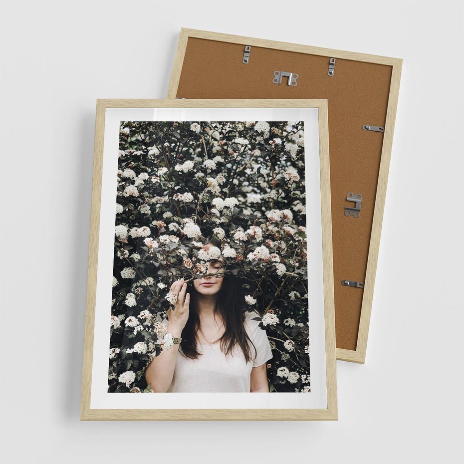 Plakat w ramie 50x70 - Kobieta w Krzewie Kwiatów - krzak z kwiatami, schowana za nim kobieta - rama drewno