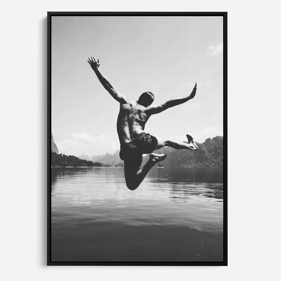 Obraz w ramie 70x100 - Beztroska Chwila - czarno biała fotografia, mężczyzna wesoło wskakuje do keziora w górach - rama czarna