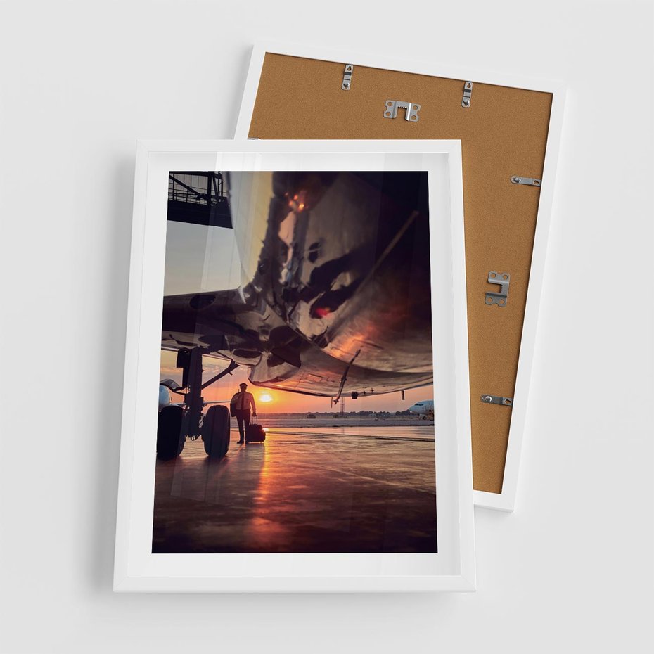 Plakat w ramie 50x70 - Podróż ku Zachodzącemu Słońcu - samolot, scena na lotnisku - rama biała