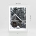 Plakat w ramie 30x40 - Zaklęta Zima - domek w lesie, śnieg - rama biała