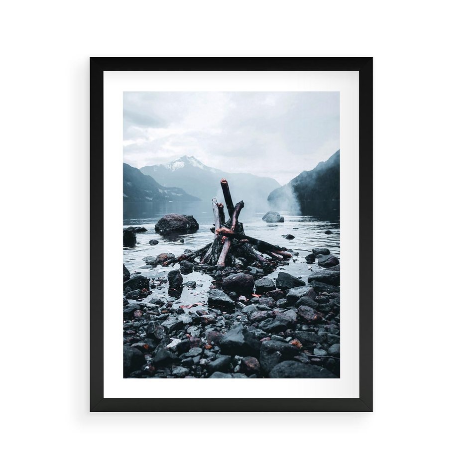 Plakat w ramie 40x50 - To ujęcie jeziora w górach z zgaszonym ogniskiem nad brzegiem, tworząc atmosferę spokoju i refleksji w otoczeniu przyrody. - jezioro w górach, zgaszone ognisko - rama czarna