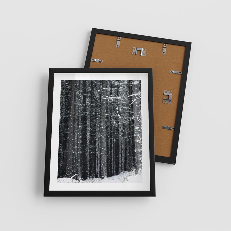 Plakat w ramie 40x50 - Leśna Cisza: Malowniczy Pejzaż Zimą - las zimą, ośnieżone pnie drzew - rama czarna