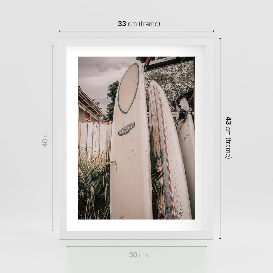 Plakat w ramie 30x40 - Deski Surfingowe czekają na Fale - deski surfingowe, stoją pod płotem - rama biała