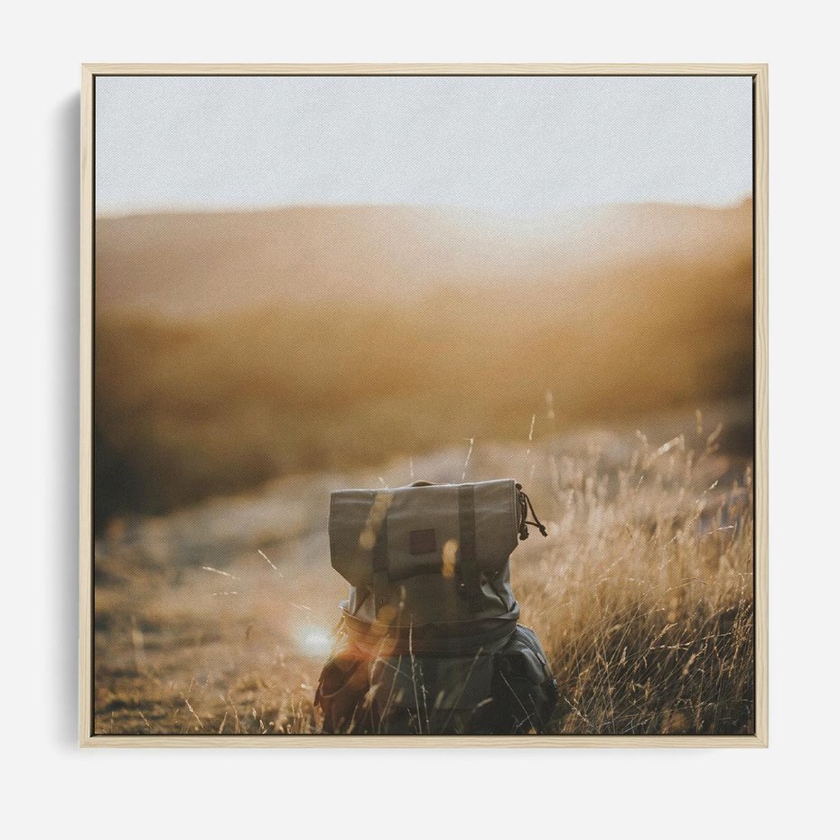 Obraz w ramie 50x50 - Podróżniczy bukiet na łące - plecak, podróż - rama drewno