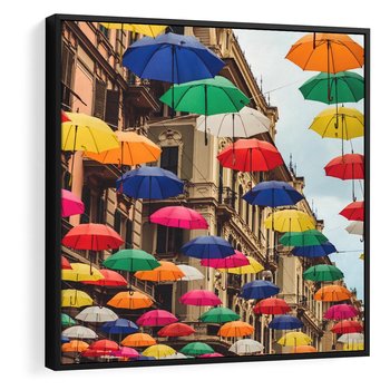 Obraz w ramie 50x50 - Barwna symfonia wyobraźni - fotografia, kolorowe parasolki podwieszone nad ulicą - rama czarna