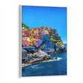 Obraz w ramie 70x100 - Barwne Wybrzeże - nadmorskie miasto na klifie, kolorowe tęczowe budynki - rama biała
