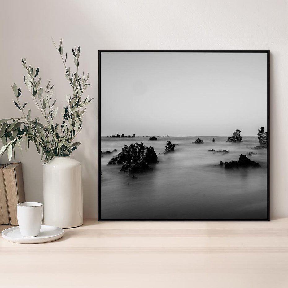 Obraz w ramie 50x50 - Harmonia świateł i cieni - zamglona dzika plaża, skały na plaży - rama czarna