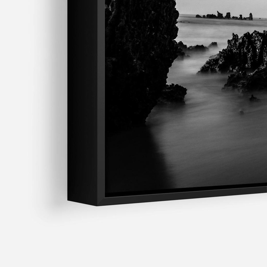 Obraz w ramie 70x50 - Harmonia świateł i cieni - zamglona dzika plaża, skały na plaży - rama czarna