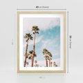 Plakat w ramie 40x50 - Tropikalna Sielskość: Palmy i Błękitne Niebo - palmy na tle błękitnego nieba - rama drewno