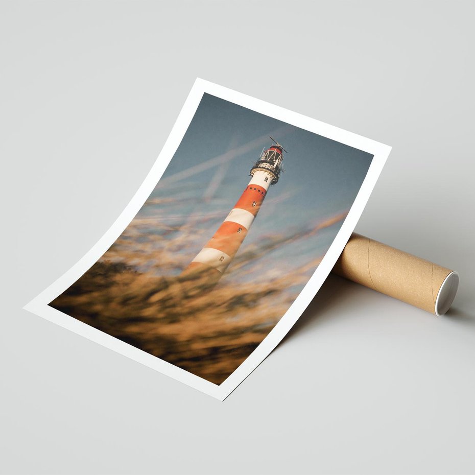 Plakat bez ramy 30x40 - Magia nadmorskiego światła - latarnia morska, ujęcie z za trawy