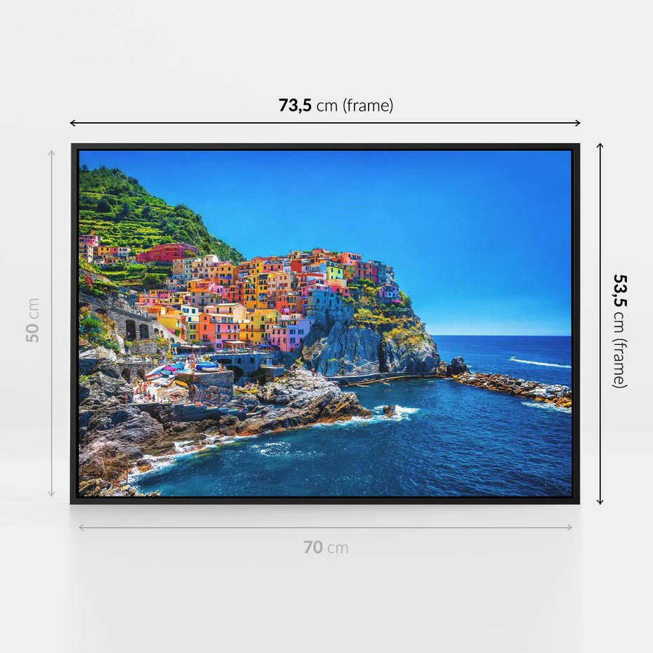 Obraz w ramie 70x50 - Barwne Wybrzeże - nadmorskie miasto na klifie, kolorowe tęczowe budynki - rama czarna