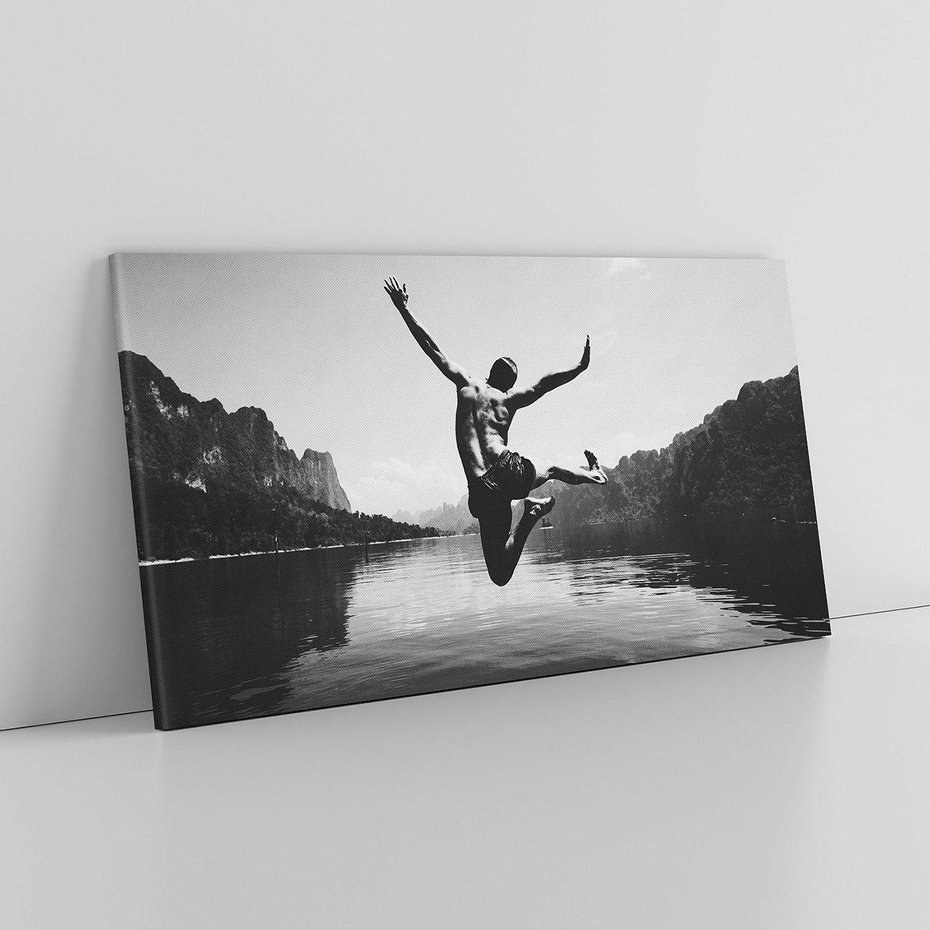 Obraz na płótnie 120x60 - Beztroska Chwila - czarno biała fotografia, mężczyzna wesoło wskakuje do keziora w górach