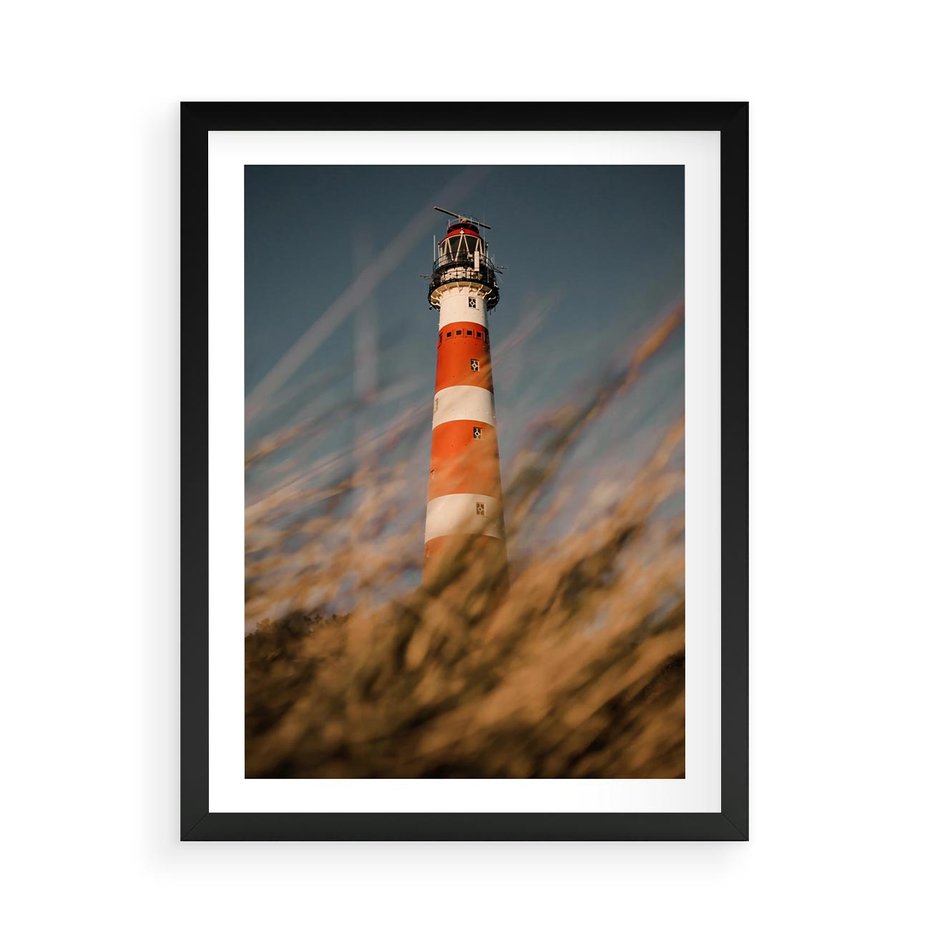 Plakat w ramie 50x70 - Magia nadmorskiego światła - latarnia morska, ujęcie z za trawy - rama czarna