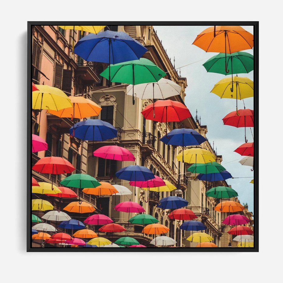 Obraz w ramie 50x50 - Barwna symfonia wyobraźni - fotografia, kolorowe parasolki podwieszone nad ulicą - rama czarna