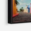 Obraz w ramie 100x70 - Ekspresja marzeń i tęsknot - pastelowe kolorowe budynki, wzdłuż ulicy - rama czarna