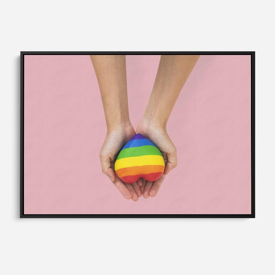 Obraz w ramie 100x70 - Miłość na Dłoniach - zdjęcie, dłonie trzymają ulepione tęczowe serce - rama czarna