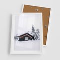Plakat w ramie 50x70 - Zimowy Azyl: Domek w Górach - domek w górach, śnieg - rama biała
