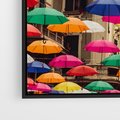 Obraz w ramie 50x70 - Barwna symfonia wyobraźni - fotografia, kolorowe parasolki podwieszone nad ulicą - rama czarna