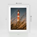 Plakat w ramie 30x40 - Magia nadmorskiego światła - latarnia morska, ujęcie z za trawy - rama biała