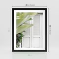Plakat w ramie 40x50 - Tropikalne Okno - białe okiennice, zielona tropikalna roślina - rama czarna