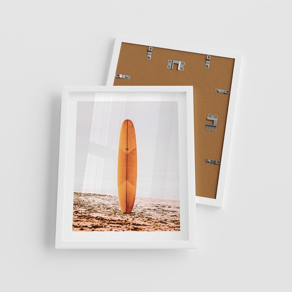 Plakat w ramie 40x50 - Deska w Piasku: Gotowa na Fale - plaża, pomarańczowa deska surfingowa wbita w piasek - rama biała
