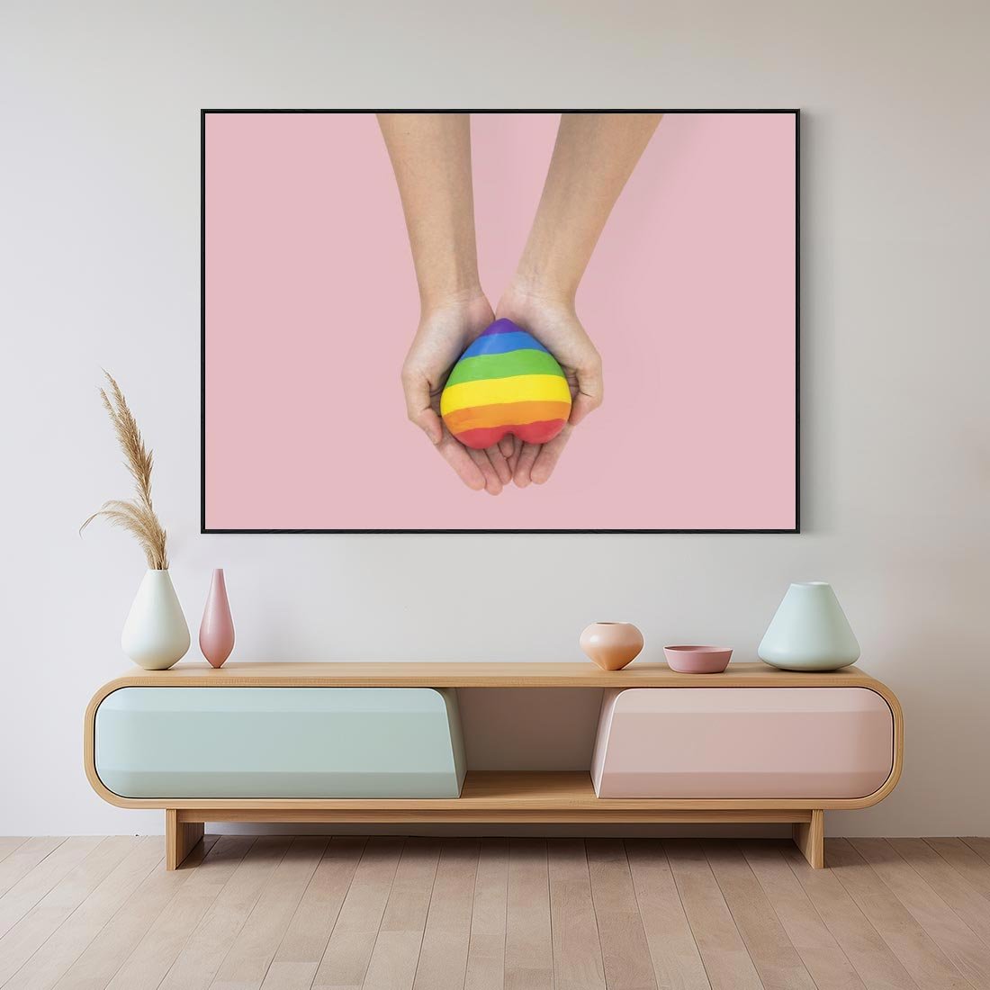 Obraz w ramie 100x70 - Miłość na Dłoniach - zdjęcie, dłonie trzymają ulepione tęczowe serce - rama czarna