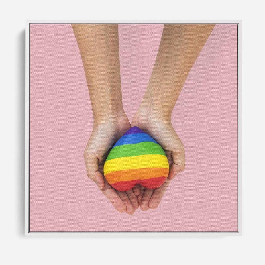 Obraz w ramie 80x80 - Miłość na Dłoniach - zdjęcie, dłonie trzymają ulepione tęczowe serce - rama biała