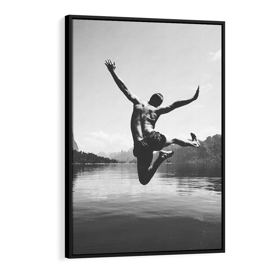 Obraz w ramie 70x100 - Beztroska Chwila - czarno biała fotografia, mężczyzna wesoło wskakuje do keziora w górach - rama czarna