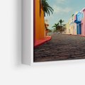 Obraz w ramie 100x70 - Ekspresja marzeń i tęsknot - pastelowe kolorowe budynki, wzdłuż ulicy - rama biała