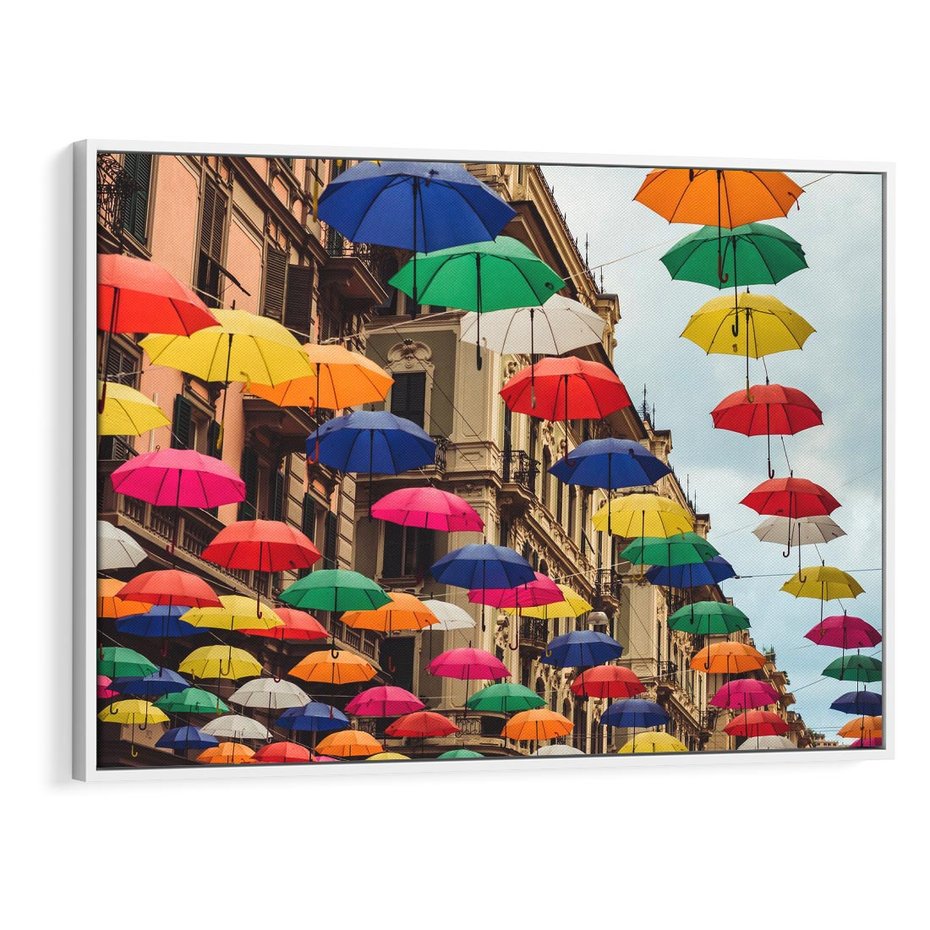Obraz w ramie 100x70 - Barwna symfonia wyobraźni - fotografia, kolorowe parasolki podwieszone nad ulicą - rama biała