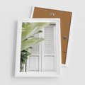 Plakat w ramie 50x70 - Tropikalne Okno - białe okiennice, zielona tropikalna roślina - rama biała