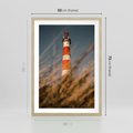 Plakat w ramie 50x70 - Magia nadmorskiego światła - latarnia morska, ujęcie z za trawy - rama drewno