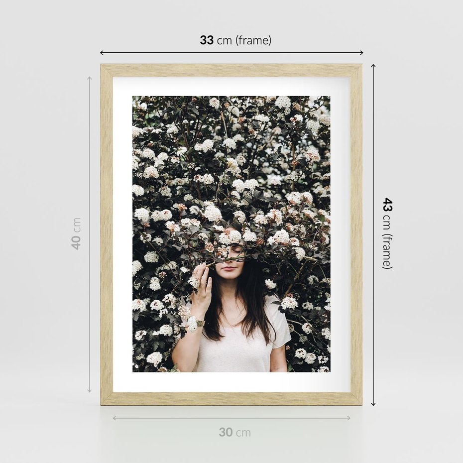 Plakat w ramie 30x40 - Kobieta w Krzewie Kwiatów - krzak z kwiatami, schowana za nim kobieta - rama drewno