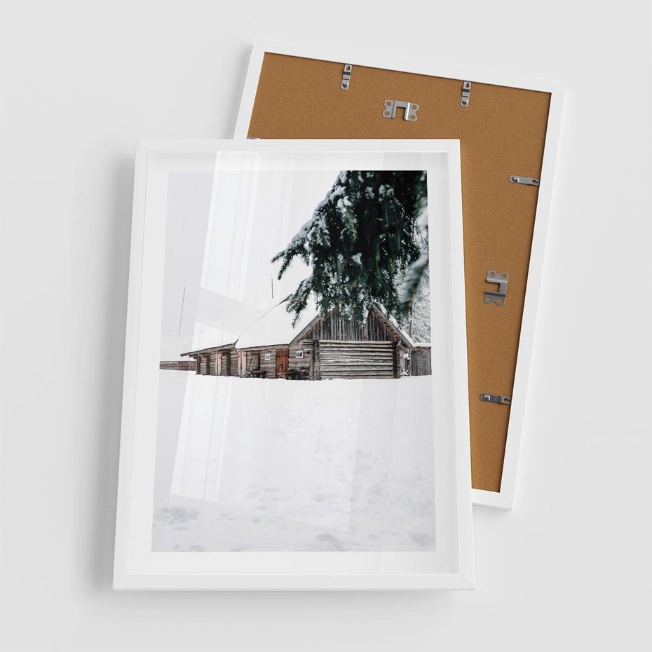 Plakat w ramie 50x70 - Zimowy Azyl - domek w górach, śnieg - rama biała