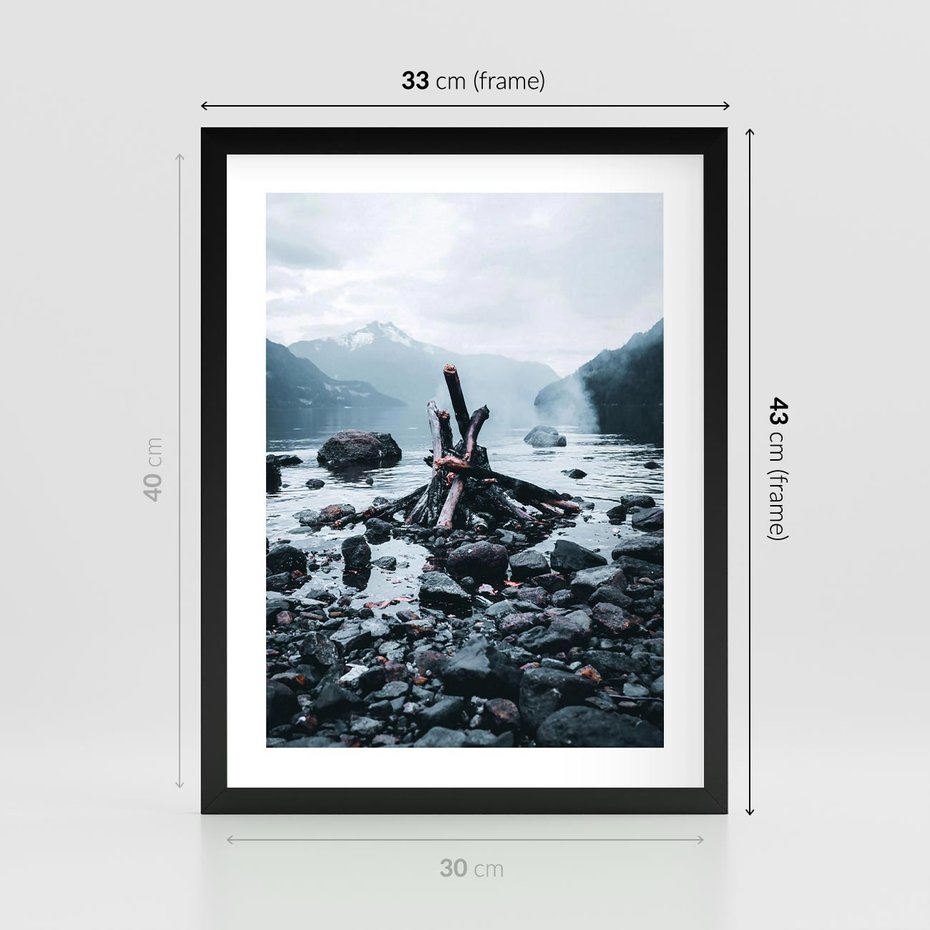 Plakat w ramie 30x40 - To ujęcie jeziora w górach z zgaszonym ogniskiem nad brzegiem, tworząc atmosferę spokoju i refleksji w otoczeniu przyrody. - jezioro w górach, zgaszone ognisko - rama czarna