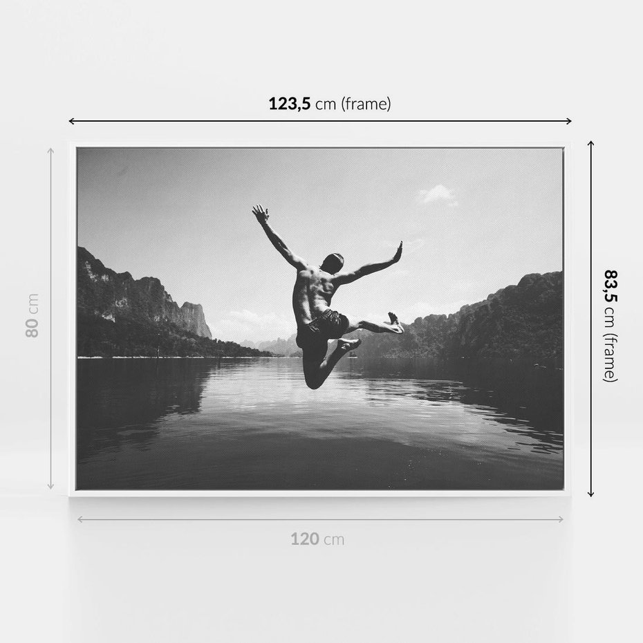 Obraz w ramie 120x80 - Beztroska Chwila - czarno biała fotografia, mężczyzna wesoło wskakuje do keziora w górach - rama biała
