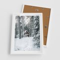 Plakat w ramie 50x70 - Spokój Zimowej Przygody w Lesie - domek w górach w lesie, zima - rama biała