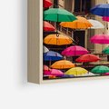 Obraz w ramie 70x100 - Barwna symfonia wyobraźni - fotografia, kolorowe parasolki podwieszone nad ulicą - rama drewno