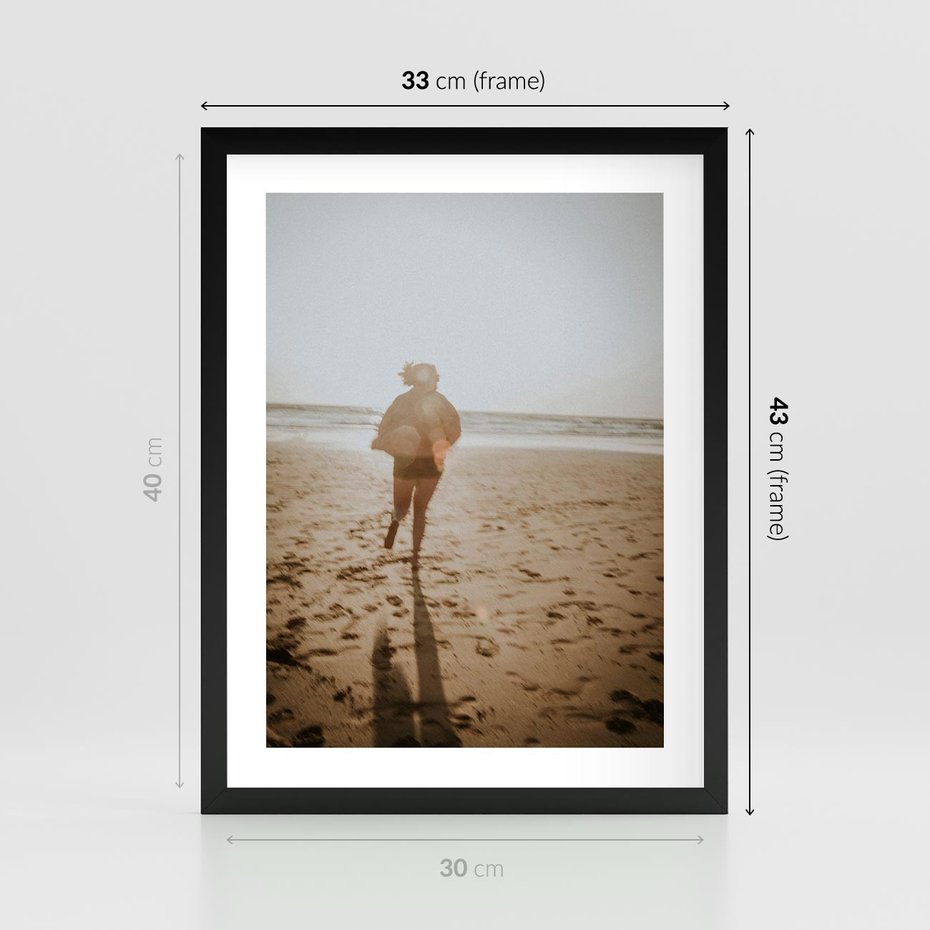 Plakat w ramie 30x40 - O Zachodzie Słońca - klimatyczna fotografia, postać biegnie po plaży - rama czarna