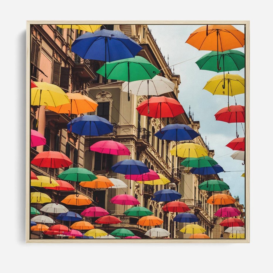 Obraz w ramie 50x50 - Barwna symfonia wyobraźni - fotografia, kolorowe parasolki podwieszone nad ulicą - rama drewno