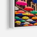 Obraz w ramie 120x80 - Barwna symfonia wyobraźni - fotografia, kolorowe parasolki podwieszone nad ulicą - rama biała